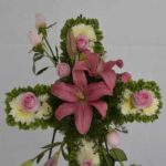 cruz con lirio rosa y flores blancos