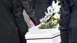 ataud blanco con flores encima