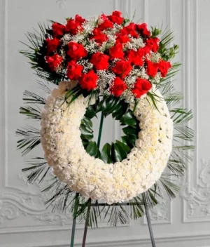 Corona fúnebre de pompones blancos con rosas rojas