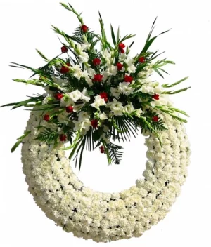 Corona fúnebre de pompones blancos con rosas rojas y azucenas