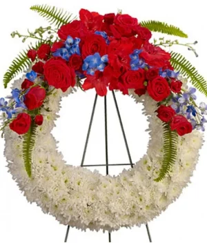 Corona funeral de pompones blancos con rosas rojas y iris azul